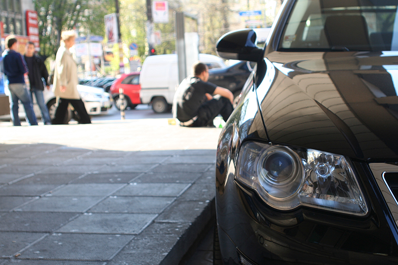 Detalhe da lanterna dianteira de um carro na coloração preta.