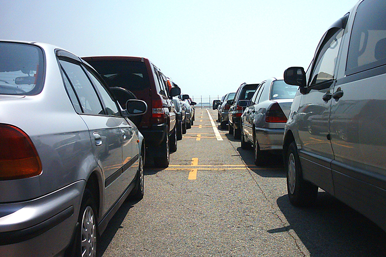 vários carros estacionados frente a frente em um estacionamento aberto