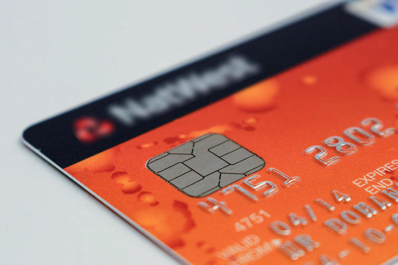Detalhe de um cartão de crédito na cor laranja.