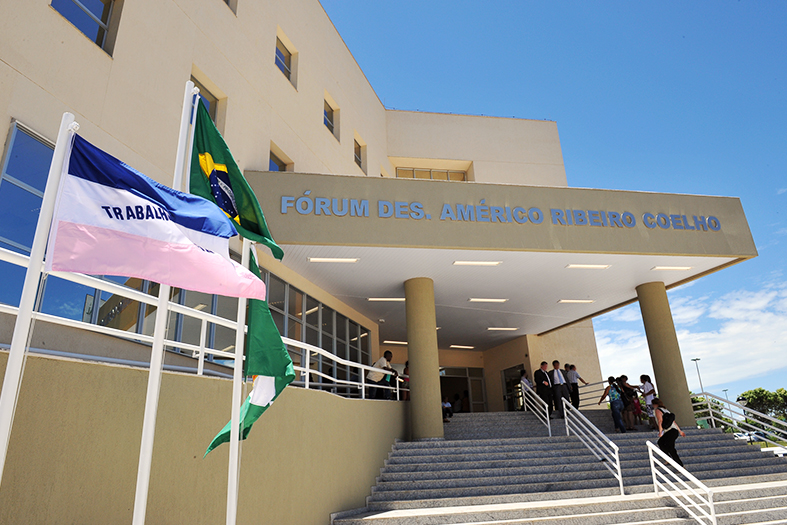 Fachada do Fórum de Cariacica com as bandeiras do Estado do Espírito Santo e a do Brasil tremulando ao vento