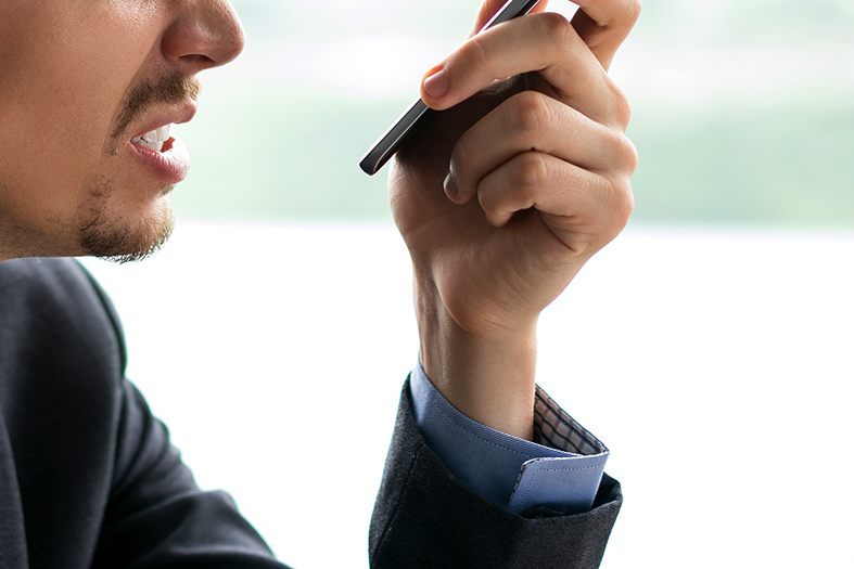 Detalhe de um homem com expressão de raiva e um smartphone na mão.