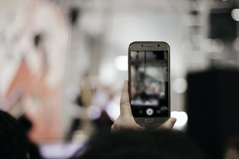 Mão de pessoa filmando com o celular.