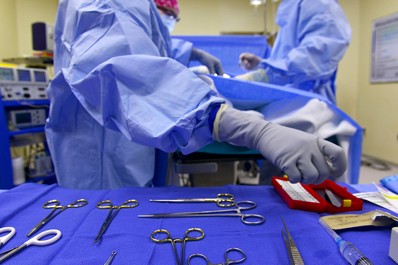 Dois médicos aprontando equipamentos para cirurgia.