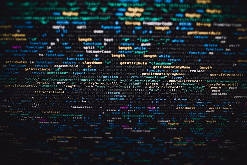 Detalhe de tela de computador repleta de linhas de código de informática.