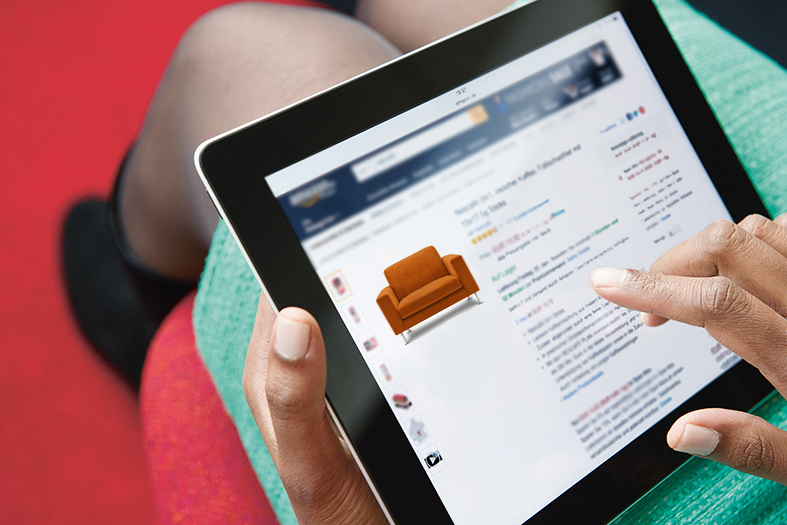 Mulher realiza compra de móveis online através de tablet repousado em seu colo.