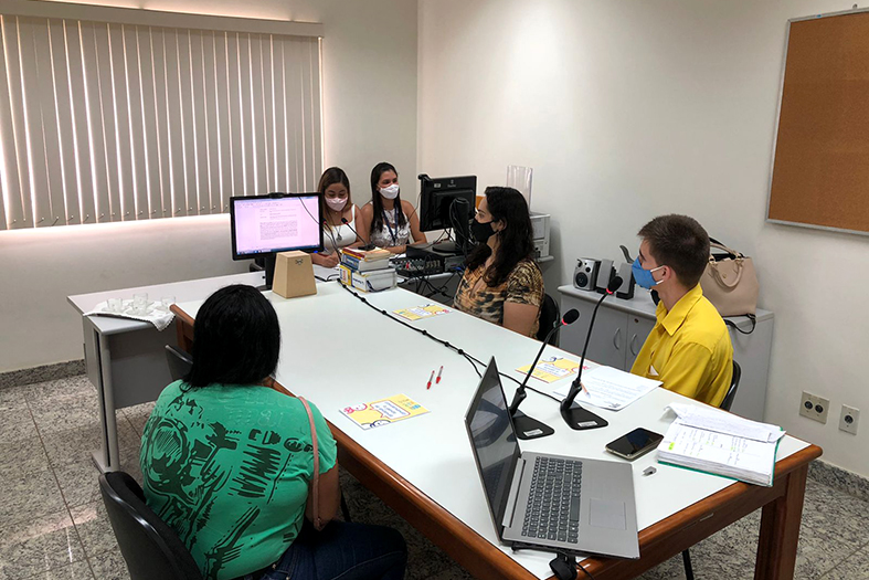 Pessoas dentro de uma sala de audiências dentro do fórum de Marilândia/ES.