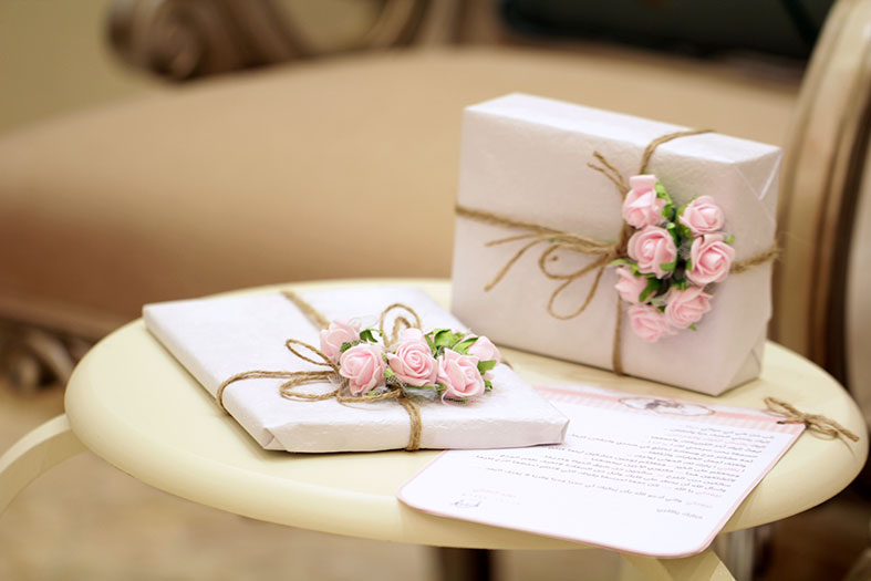 convites de casamento decorados com rosas e fitas douradas.