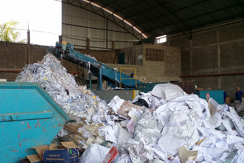 Galpão de reciclagem de papel. pilhas de papéis são jogados no montante.