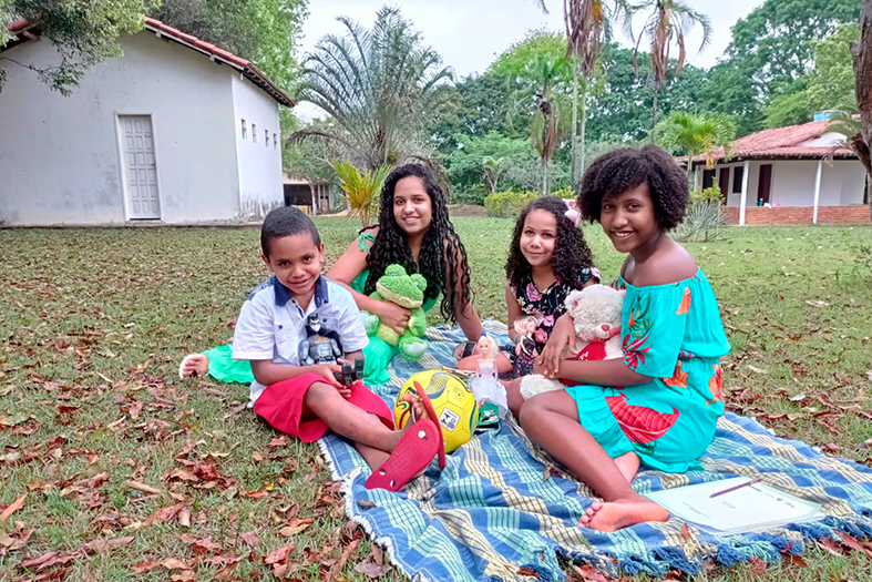 Grupo de irmãos posa para foto em área gramada.