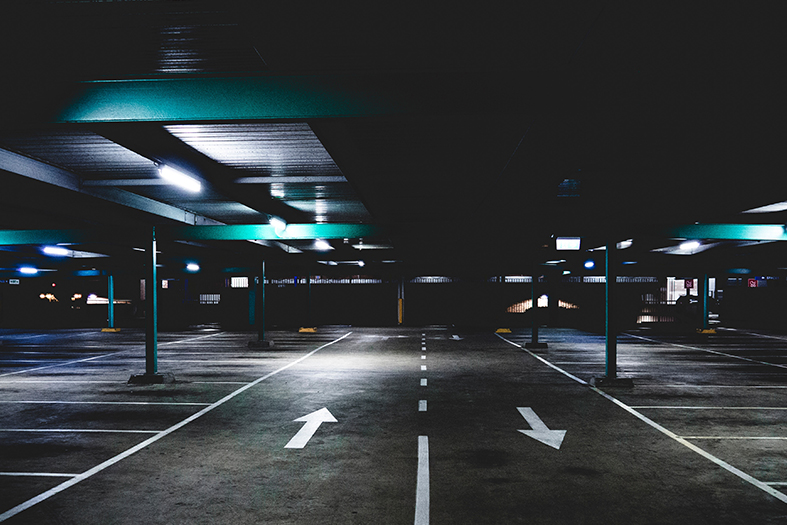 Estacionamento a céu aberto à noite.