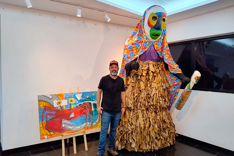 O artista plástico Rodrigo Brito posa ao lado de suas obras.