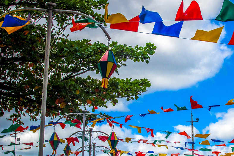decoração de festa junina. bandeirolas e balões decorativos. ao fundo céu com nuvens brancas.