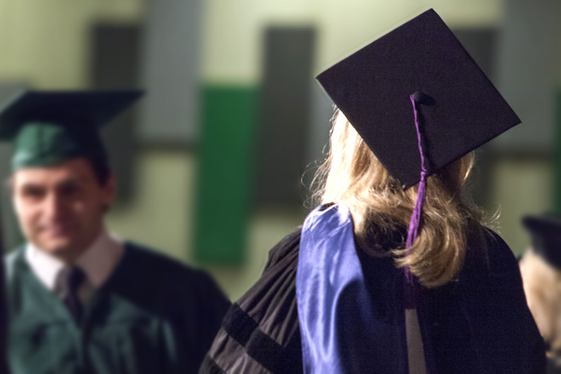 Pessoas de costas em trajes de formatura.