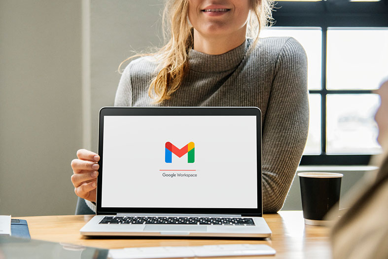 Mulher mostrando computador onde vemos a tela inicial do google workspace.
