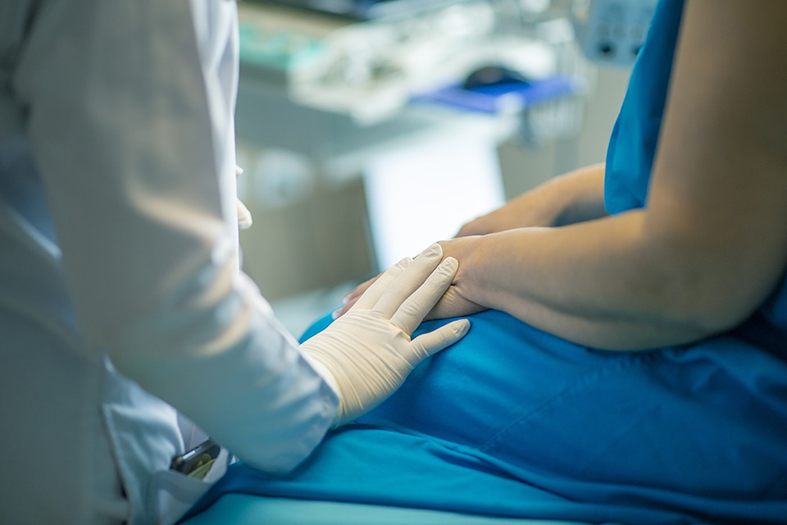 um médico atende uma paciente em um leito de hospital