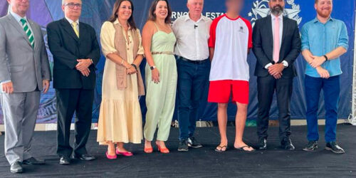 Grupo de pessoas posa para foto.