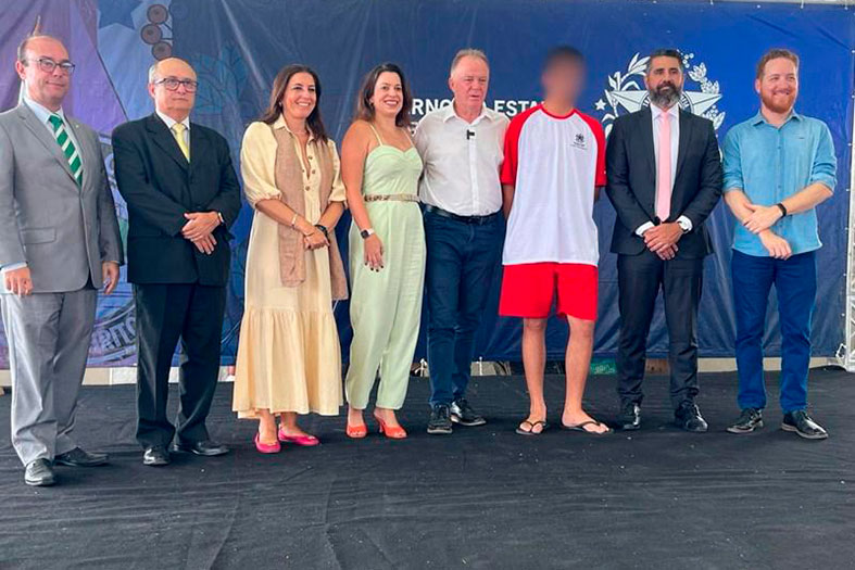 Grupo de pessoas posa para foto.