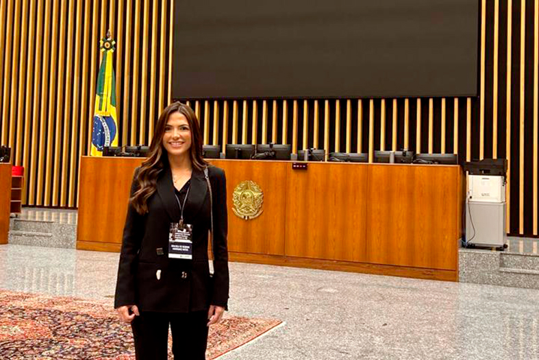 A juíza Graciela de Rezende Henriquez mulher de pele branca, ela tem cabelos na cor preta. A juíza está em um salão do STJ em Brasília e ela veste um terno feminino na cor preta.