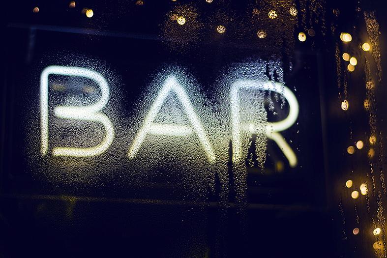 Letreiro em neon com a palavra "bar" em maiúsculas.
