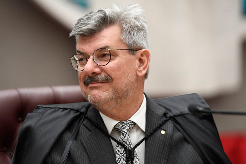 O Ministro do STJ, Marco Buzzi, é um homem de pele branca com cabelos e barba grisalhos.