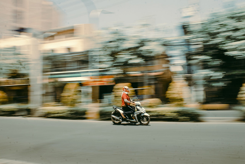 Motociclista andando em alta velocidade na cidade.