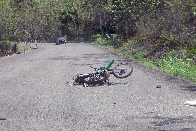 Motocicleta caída em estrada.