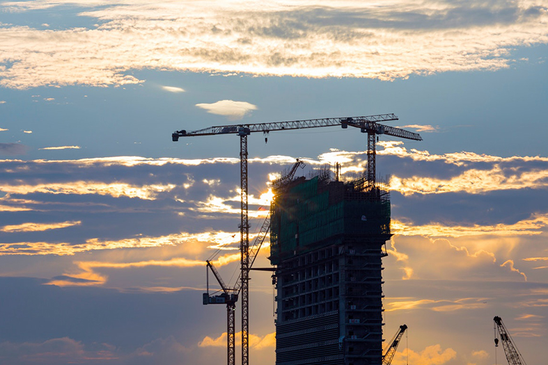 Edifício de concreto inacabado com guindaste de torre.