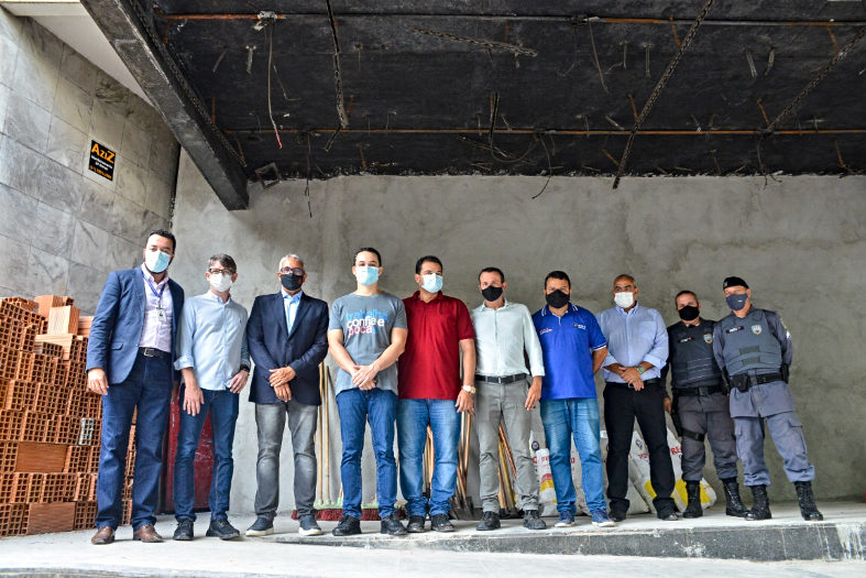 Grupo de autoridades posando para foto em um andar em obras.