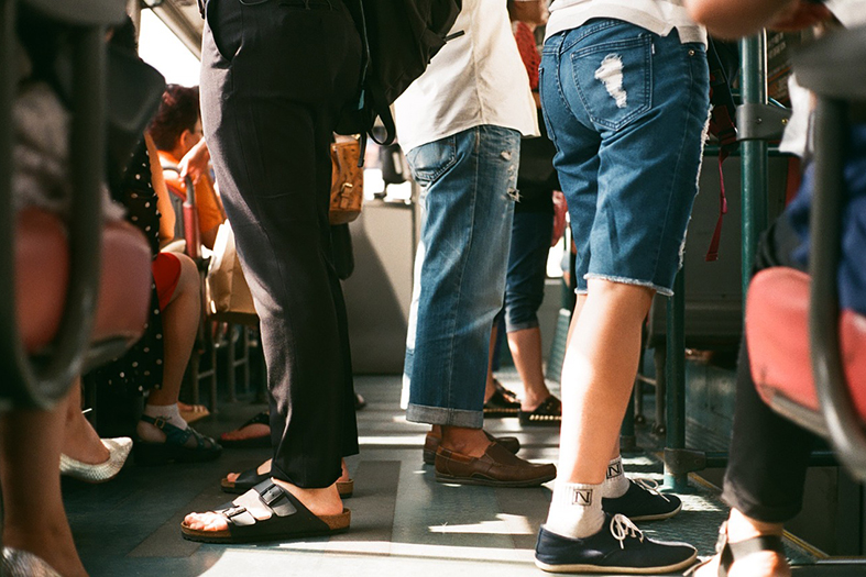 Visão das pernas de passageiros viajando em um ônibus.