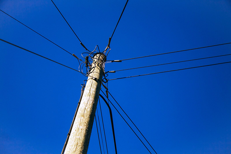 visão de baixo para cima de um poste de rua com fiações.