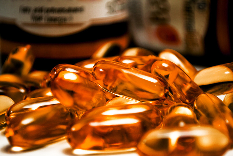 Medicamentos em drágeas transparentes com líquido amarelado dentro.