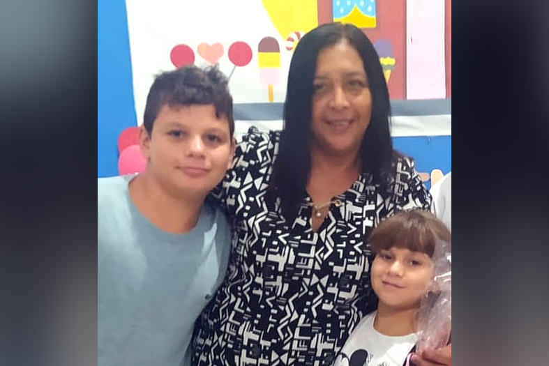 Mãe e casal de filhos posam para foto.