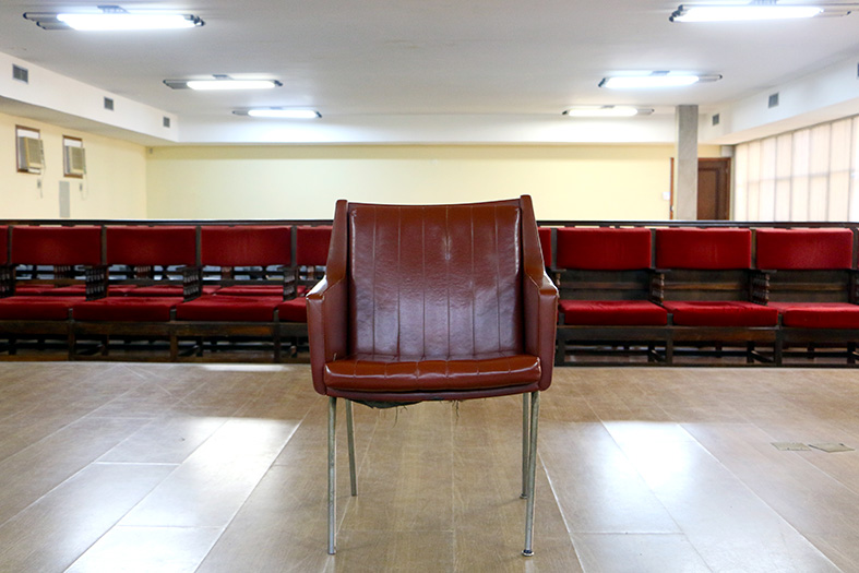 tribunal do juri do fórum criminal de vitória. o tribunal está vazio. em primeiro plano está a cadeira do reú, ao fundo estão as cadeiras do público.