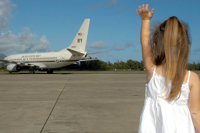 Menina dando adeus a um avião.