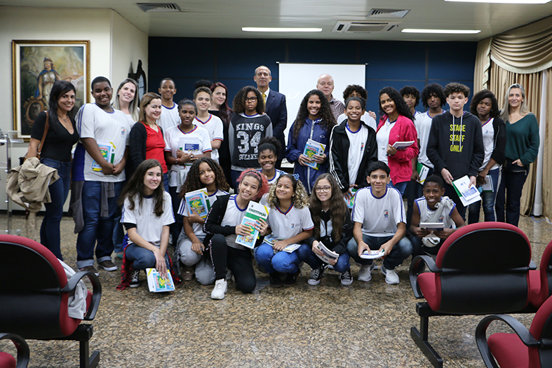 Grupo de pessoas posando para fotografia dentro de um salão.