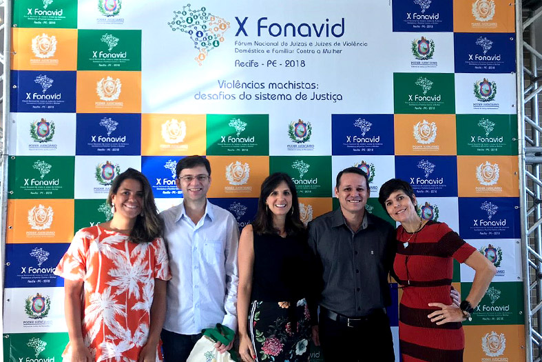 Servidores e Juízes da Justiça Capixaba posam em frente ao painél do evento FONAVID.